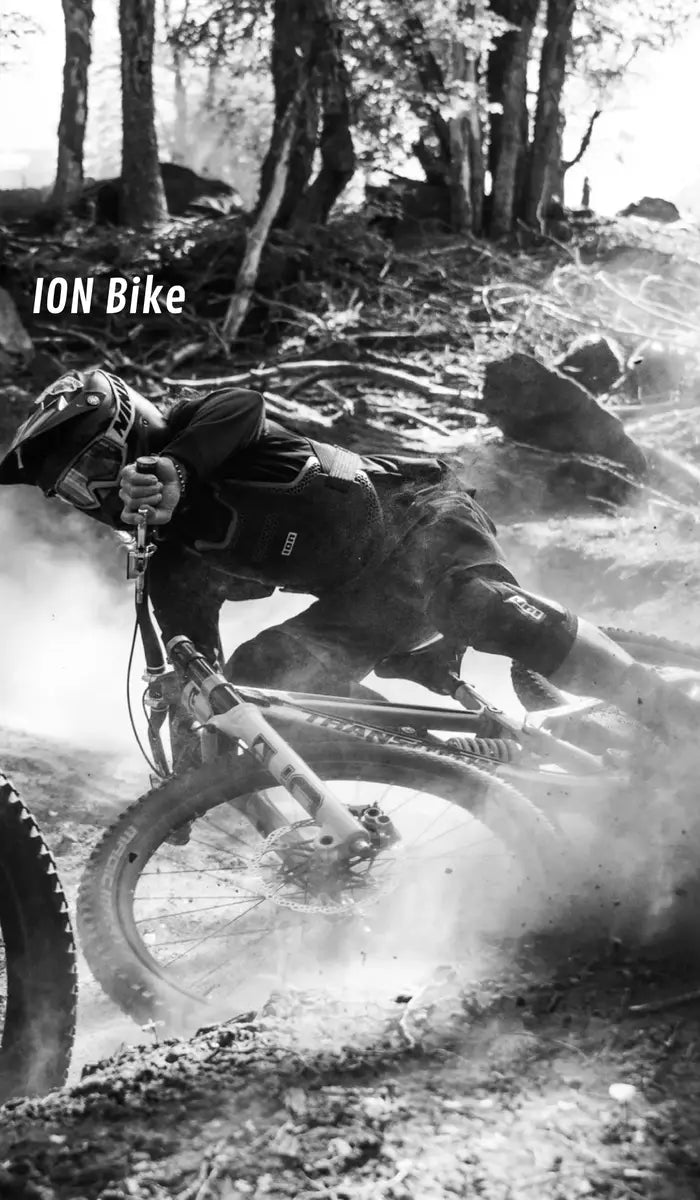 Black and white action shot of a mountain biker in mid-air with 'ION Bike' branding.